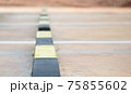 Row of concrete wheel stopper, selective soft focus. 75855602