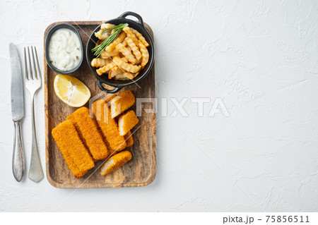 Pile of golden fried fish fingers with white garlic sauce, on wooden tray, on white background, top view flat lay , with copyspace and space for text 75856511