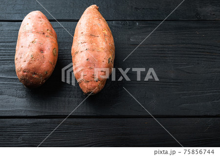 Sweet potato or batat, on black wooden background with space for text Sweet potato or batat, on black wooden background with space for text 75856744