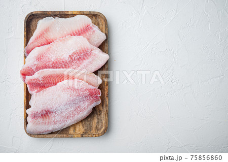 Frozen white fish fillet, on white background, top view with copy space for text 75856860