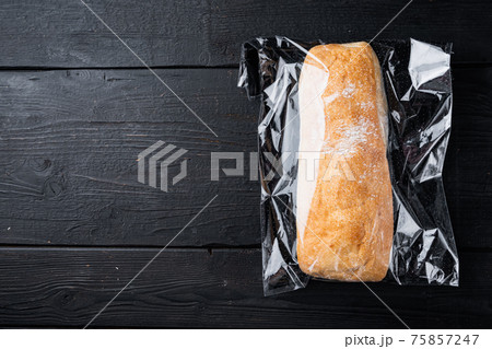 Ciabatta panini bread in plastic bag, on black wooden table background, top view flat lay , with copyspace and space for text Ciabatta panini bread in plastic bag, on black wooden table background, top view flat lay , with copyspace and space for text 75857247