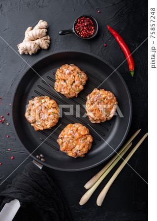 Quick asian raw fishcakes, on black textured background, top view 75857248