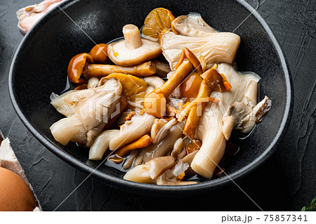 Wild mushrooms Boletus edulis and cap boletus in a jar, on black background Wild mushrooms Boletus edulis and cap boletus in a jar, on black background 75857341