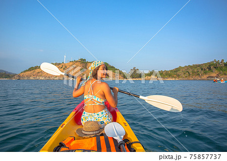 Women tourists wear bikinis and ride a canoe. Women tourists wear bikinis and ride a canoe. 75857737