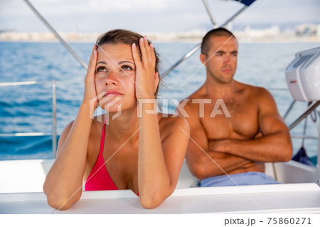 Frustrated woman with husband at sailboat Frustrated woman with husband at sailboat 75860271