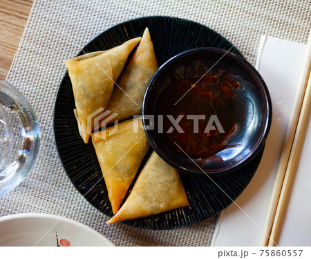Potato curry samosas served with sause at plate Potato curry samosas served with sause at plate 75860557