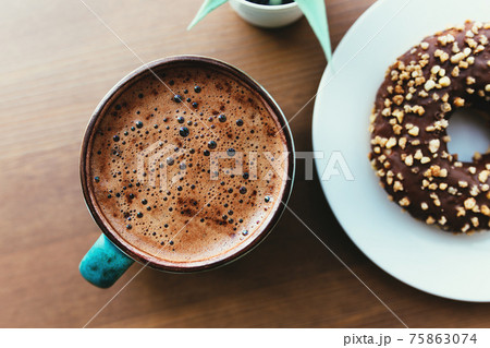 Donuts on the white plate and coffee on the wooden table Donuts on the white plate and coffee on the wooden table 75863074