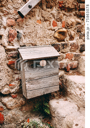 Old wooden post box on stone wall in Perouges, France 75863078