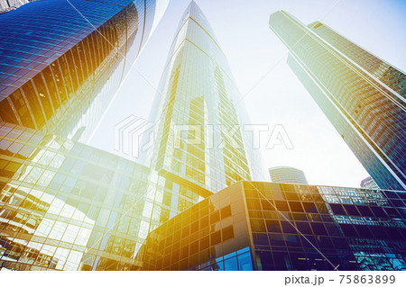Skyscraper glass facades on a bright sunny day with sunbeams in the blue sky. Modern buildings in Moscow business district La Defense. Bottom up view 75863899