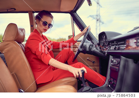 Beautiful young woman in retro car 75864503