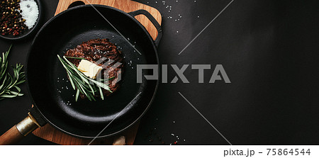 Cooked ribeye steak, cast-iron pan, pepper, rosemary, salt, garlic, butter 75864544