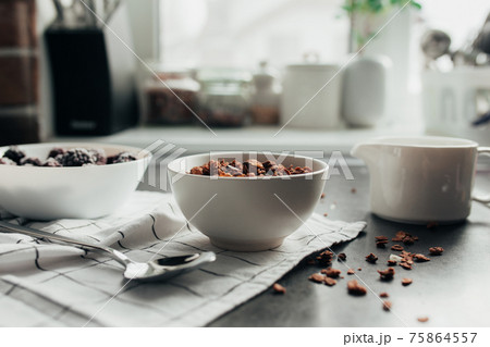 Frozen blackberries, granola, cream, towel on table. Blurred background 75864557