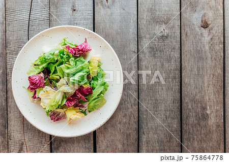 Healthy eating concept flat lay. Salad mix on the plate on wooden background Healthy eating concept flat lay. Salad mix on the plate on wooden background 75864778