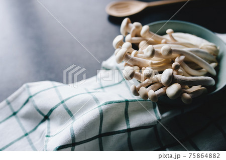 Cooking white mushrooms on the dark gray background Cooking white mushrooms on the dark gray background 75864882