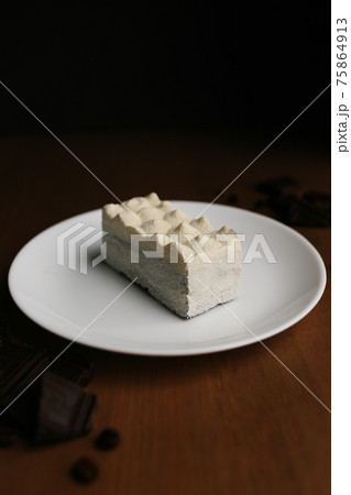 White cheese cake on plate on brown wooden table, chocolate. Blurred background 75864913