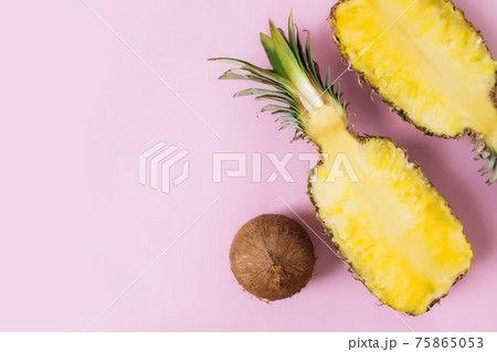 Cut halves of fresh pineapple, coconut on pastel pink background. Exotic fruit 75865053
