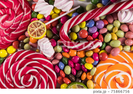 Background of colorful chocolate candies, lollipops, candy cane and marshmallows 75866756