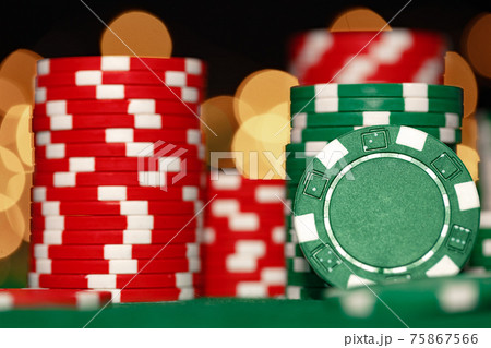 Stack of casino chips on green table against bokeh background Stack of casino chips on green table against bokeh background 75867566