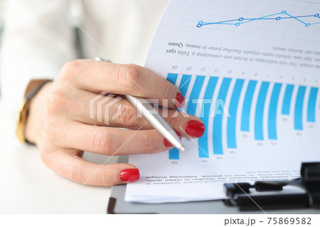 Female hand leafing documents with graphs on clipboard closeup Female hand leafing documents with graphs on clipboard closeup 75869582