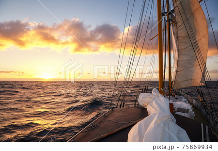 Sailing old schooner at sunset, travel and adventure concept. Sailing old schooner at sunset, travel and adventure concept. 75869934