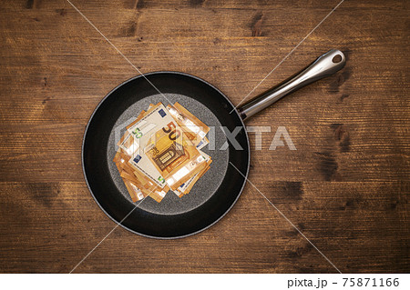 Euro bills in a frying pan 75871166
