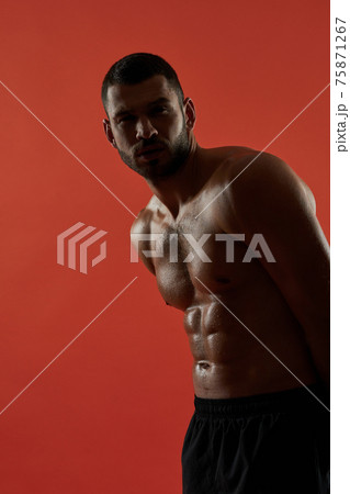 Strong Caucasian athlete isolated on red background 75871267