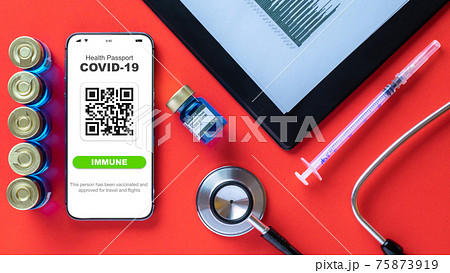 Immune passport. Coronavirus immunity certificate or vaccine passport on smartphone screen with doctor stethoscope, healthcare charts, syringe and medical equipment on hospital red background. 75873919