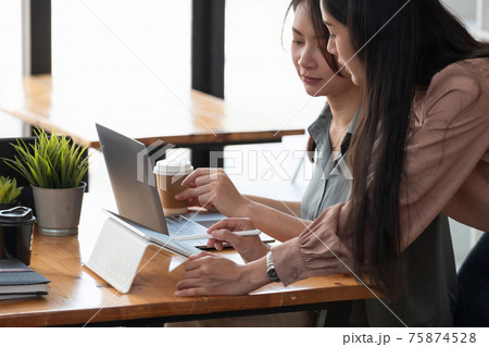 Close up two women discussing business projects in a cafe while having coffee. Startup, ideas and brain storm concept. 75874528