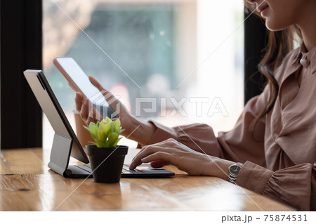 Shot of business woman holding smartphone getting message during making transaction on laptop computer 75874531