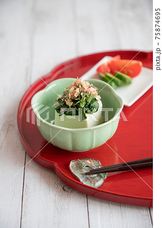 赤い輪花盆に乗せた夏の和のお惣菜（ツルムラサキのお浸しon冷や奴、きゅうりのぬか漬け・トマト）② 75874695