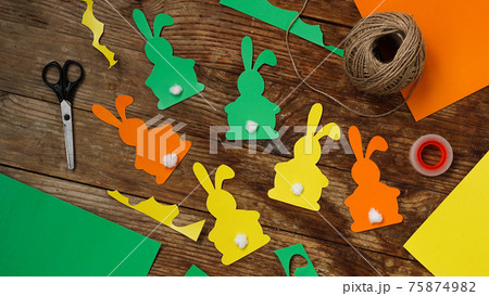 Easter bunnies made of paper on a wooden background. Create a decor for easter Easter bunnies made of paper on a wooden background. Create a decor for easter 75874982