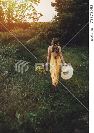 Summer outfit, Summer fashion, natural beauty. Outdoor candid portrait Young blonde woman n ristic yellow dress and straw hat on green field nature background Summer outfit, Summer fashion, natural beauty. Outdoor candid portrait Young blonde woman n ristic yellow dress and straw hat on green field nature background 75875092