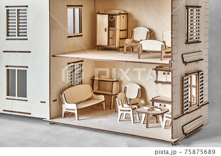 Laser cut doll house with small furniture made of plywood details closeup 75875689