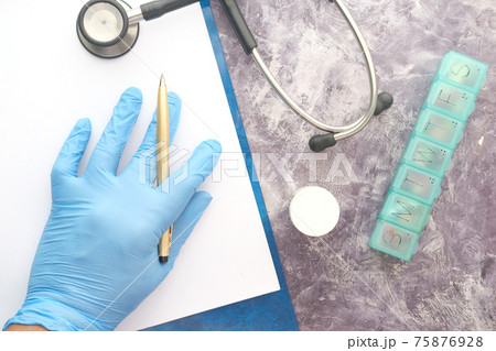 doctor hand in latex gloves writing prescription on desk, close up. doctor hand in latex gloves writing prescription on desk, close up. 75876928