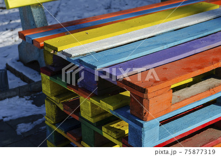 Stack of colorful wooden pallets outside. Containers are designed for the transportation, packing, storage, and warehousing of products. Selective Focus. 75877319