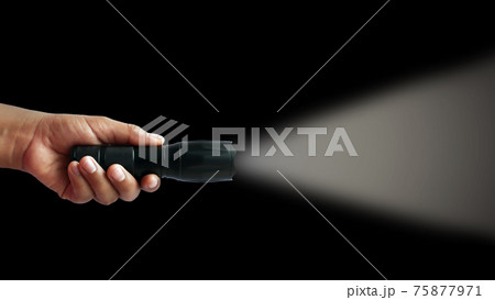 Black flashlight in human hands on a black background, including a white beam. 75877971