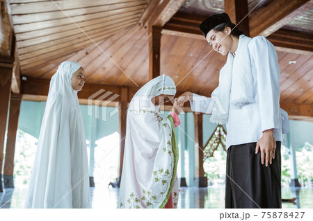 portrait of girls kissing the hand of a male Muslim teacher before returning to home portrait of girls kissing the hand of a male Muslim teacher before returning to home 75878427