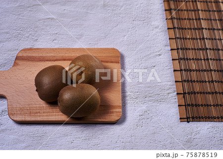Kiwi on wooden chopping board 75878519