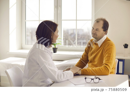 Friendly female doctor holds the patient's hand and assures that everything will be fine. Friendly female doctor holds the patient's hand and assures that everything will be fine. 75880509