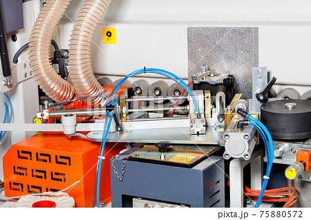 Rear end of modern woodworking machine with motors, pressure rollers and sawdust removal system. 75880572