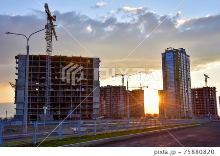 View on the large construction site with tower cranes and buildings on sunset background.  75880820