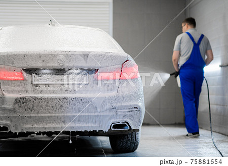 Car washing process. Foaming detergent covers side of the car, clean it from dirt and dust. 75881654