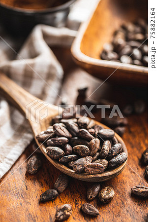 Roasted cocoa beans in wooden spoon 75882164