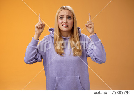 Worried perplexed unsure cute blond woman presenting project standing awkward afraid humiliation crining scared pointing up raised index finger waiting reply nervously, orange background Worried perplexed unsure cute blond woman presenting project standing awkward afraid humiliation crining scared pointing up raised index finger waiting reply nervously, orange background 75885790