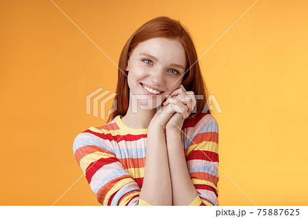 Romantic tender sensual attractive smiling redhead girlfriend melting heart feel warmth delighted lean palms grinning happily sweet gentle gift standing pleased orange background rejoicing thankful Romantic tender sensual attractive smiling redhead girlfriend melting heart feel warmth delighted lean palms grinning happily sweet gentle gift standing pleased orange background rejoicing thankful 75887625
