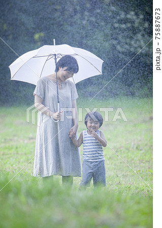 雨の日に傘をさして歩く親子 雨の日に傘をさして歩く親子 75887673