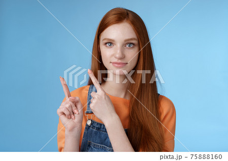 Assertive good-looking redhead girl know what talking about pointing upper left corner index fingers showing confidently good product recommend check out standing blue background 75888160