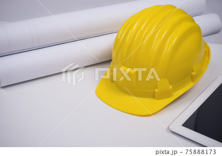 Yellow helmet and rolled paper. Yellow helmet and rolled paper. 75888173