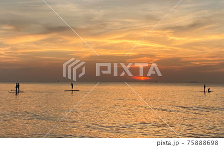 Silhouette of Stand Up Paddle board on the beach at sunset. Surfer and ocean. Side view. Silhouette of Stand Up Paddle board on the beach at sunset. Surfer and ocean. Side view. 75888698