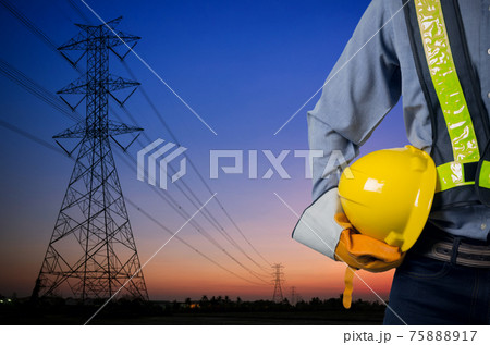 Engineer holding yellow helmet with Transmission tower. Engineer holding yellow helmet with Transmission tower. 75888917